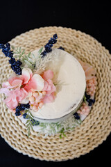 Close-up of elegant white wedding cake with pink flower decor