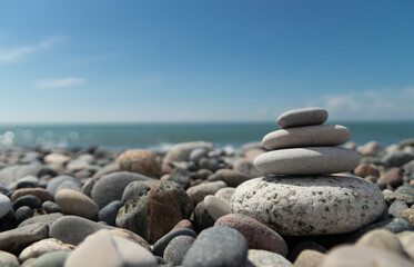 A pyramid of pebbles by the sea, embodying the concept of Zen, meditation and relaxation,a copy space