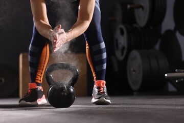 Sportswoman with kettlebell during crossfit workout in gym, closeup