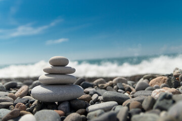 A pyramid of pebbles by the sea, embodying the concept of Zen, meditation and relaxation,a copy space