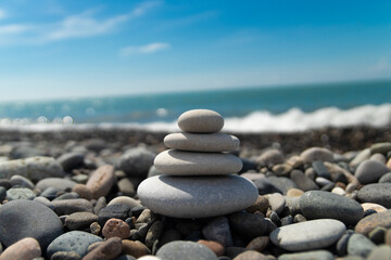 smooth white stones on the seashore stacked in a pyramid, zen, relaxation, yoga,relaxation