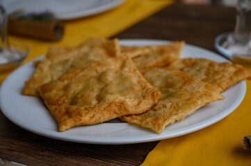 Delicious freshly fried pastries served on a white plate with a vibrant yellow tablecloth