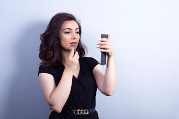 Fototapeta premium portrait of young woman holding lipstic