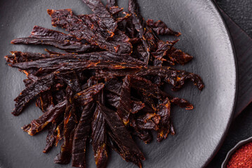 Obraz premium Jerky, dried horse meat or beef slices with salt and spices