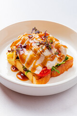 Delicate Culinary Creation of Roasted Chicken Atop Toasted Bread With Fresh Vegetables, Drizzled With Savory Sauce at a Chic Dining Spot During a Midday Meal.