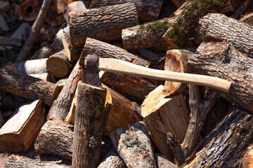 Old, worn, scratched, sharp ax standing on a wooden, cracked tree stump
