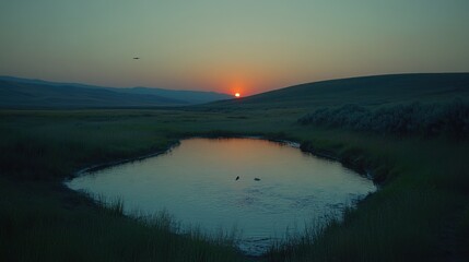 Fototapeta premium Serene Sunset Over Rolling Hills and Still Water