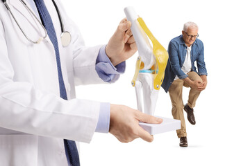 Doctor holding a knee bone model and man with leg pain standing behind
