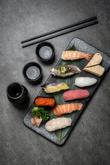 omakase mixed sushi set with sake on grey background