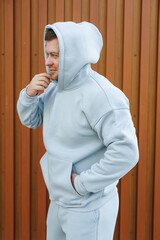 Man in a gray tracksuit. Men's fleece suit for cold walks. Men's fashion.
