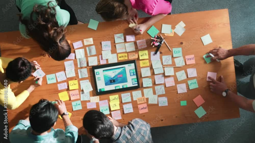 Poster top down view of programmer brainstorming and planning about web design while looking at tablet wire