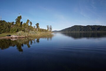Obraz premium Serene lake with lush greenery in New Zealand