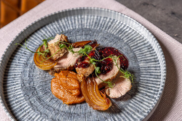 Roasted pork tenderloin with onion, sweet potato puree, and berry sauce
