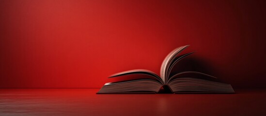 An open book resting on a red surface, showcasing its pages against a vibrant background