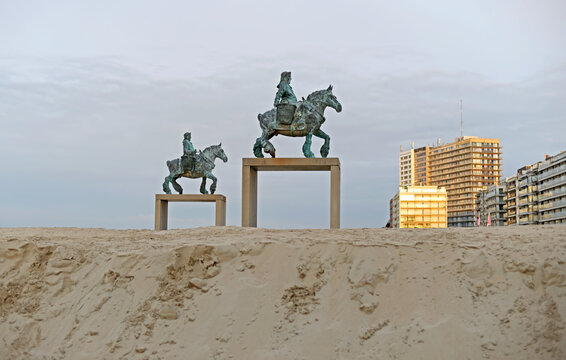 KOKSIJDE, BELGIUM &ndash; FEBRUARY 8, 2025: Bronze statues 'Cloned Paardevisser' by William Sweetlove on the beach with apartment buildings in the evening sun in the back. Selective focus