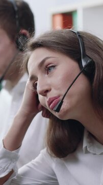 A Bored Call Center Agent at Work Wearing a Headset to Make Phone Calls for Business