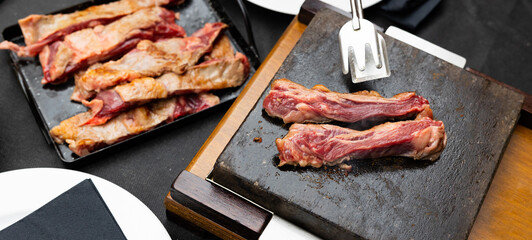 Preparing of hot stone beef on table. Meat roasting.