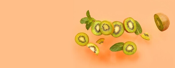 Flying kiwi and mint on orange background with space for text