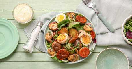 Plate of tasty potato salad with eggs and mushrooms on wooden table, top view
