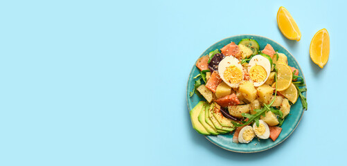 Plate of tasty potato salad with eggs and avocado on light blue background, top view
