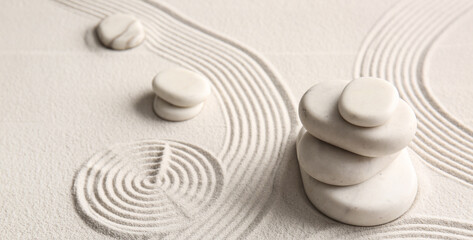 Stones on light sand with lines on Japanese rock garden. Zen concept