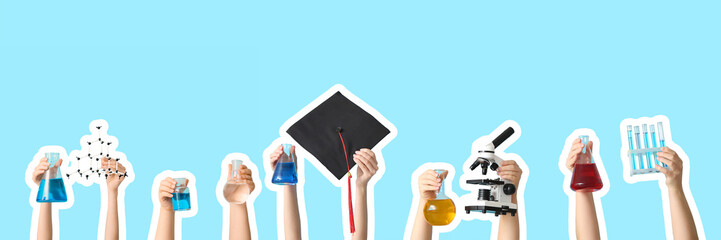 Female hands holding microscope with test tubes, graduation hat and filled flasks on blue...