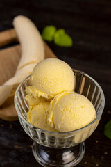 creamy ice cream with yellow banana slices in a glass cup