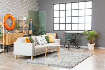 Interior of living room with ring buoy, shelf units and sofa