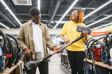 African american Couple choosing vacuum cleaner, electronics store.