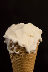 creamy ice cream in a waffle cone on a black background