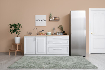 Interior of kitchen with silver fridge, counters and shelf