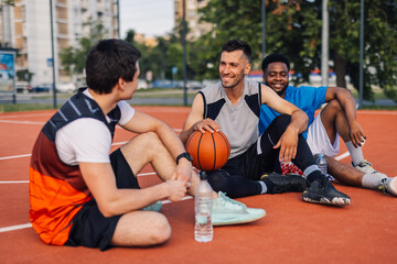 Fototapeta premium Basketball players relaxing on court after training game
