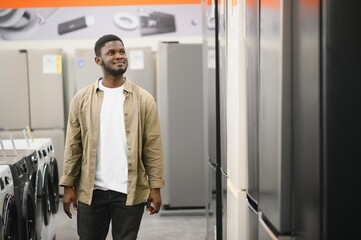 Man choosing fridge in the shop