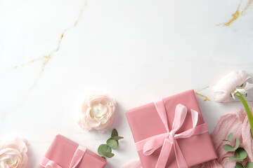 Happy Mothers Day flat lay composition with pastel pink cloth, rose ranunculus flowers and eucalyptus on marble background