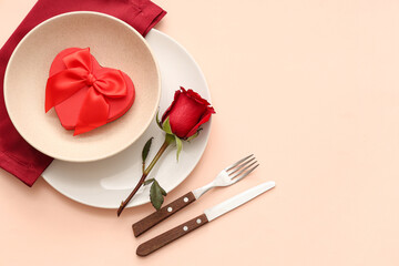 Beautiful table setting with red rose and gift box on beige background. Valentine's Day celebration