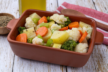 Cooked vegetables in a plate over wooden table