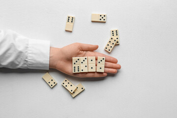 Female hand with dominoes on white background