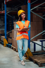Female warehouse worker taking inventory with clipboard and pen, managing logistics and distribution
