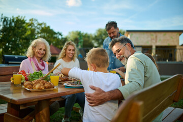 Happy family enjoying weekend barbecue garden party