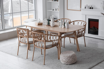 Light interior of room with dining table, fireplace and winter decor