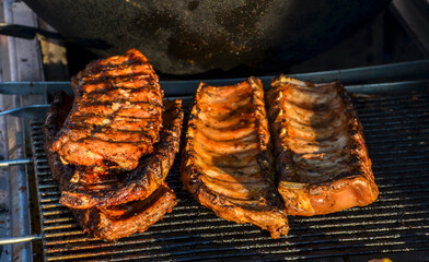 Delicious grilled barbecue pork ribs sizzling on a hot grill, perfect for outdoor gatherings and summer cookouts