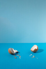 Empty eggshell with creative copy space on pastel blue background. Minimal Easter holiday concept.