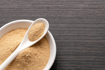 Lepidium meyenii - Organic Peruvian maca powder in spoon and bowl.