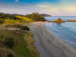 Coastal scene with photographers capturing the beauty of a secluded beach. Tranquil morning light bathes the shoreline. Elliot Bay, Rawhiti, Northland, New Zealand