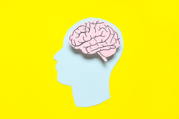 Obraz premium Paper human head with brain on yellow background. Cancer concept