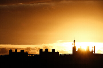 Silhouette d'un immeuble devant un coucher de soleil