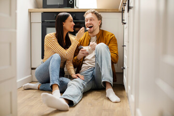 Caring relationship. Young woman feeding her handsome husband, loving wife giving her husband...