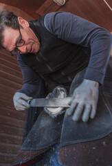 Farrier filing a horse hoof in a stable