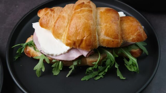aerial view of a sandwich croissant of black forest ham, panela cheese and arugula leaves, healthy food