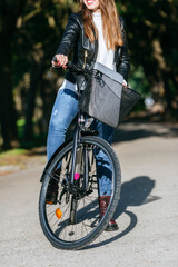 Freelancer working remotely riding bicycle in city park